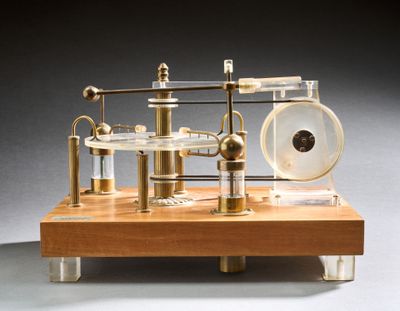 une petite maquette de machine à vapeur posée sur un socle en bois