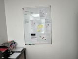a white board on the wall in the corner of a room