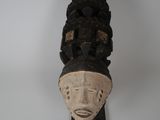 une image d'un masque en bois accroché au mur