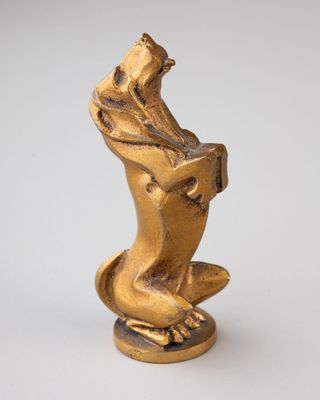 a gold statue of a dog sitting on its hind legs
