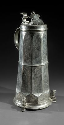 a large silverplated tankard with two birds on the top