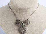 un collier en argent avec un pendentif en forme de chouette autour du cou d'un mannequin