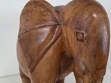a wooden elephant that is standing on a white surface