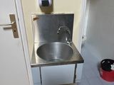 un évier en acier inoxydable dans le coin d'une salle de bains
