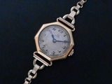 a close up of a wrist watch with a chain around it