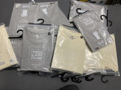 a lot of t - shirts that are sitting on top of a table