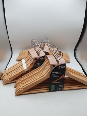trois cintres en bois exposés devant un fond blanc