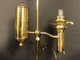an antique brass table lamp with a glass bulb on top of it