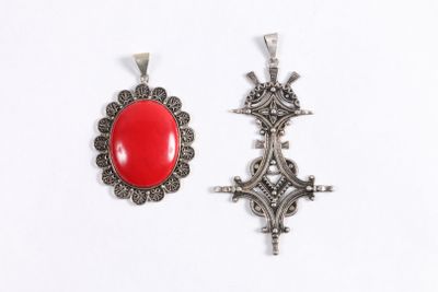 deux pendentifs en argent et pierres rouges sur fond blanc