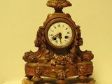 une horloge en or surmontée d'un buste