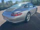 Des Porsche 911 garées sur un parking, avec des arbres en arrière-plan