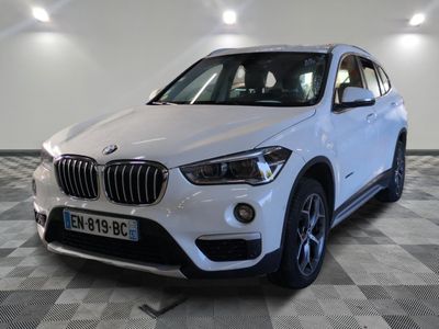 La BMW X1 est garée dans un showroom au sol à damier.