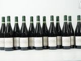 six bouteilles de vin sont alignées sur une table