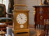a gold clock sitting on a table in a living room