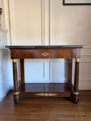 a wooden table with a marble top on a hard wood floor