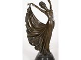 une statue en bronze représentant une femme tenant un éventail, posée sur un socle
