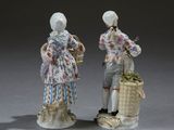 pair of porcelain figurines of a man and a woman with baskets