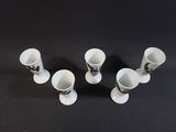 four white cups sitting on top of a black table next to each other