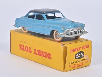 une petite voiture bleue posée sur une boîte jaune