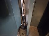 a toilet in the corner of a room with a trash can
