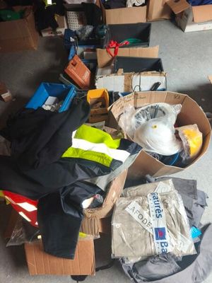 un carton rempli de vêtements et d'autres objets sur le sol