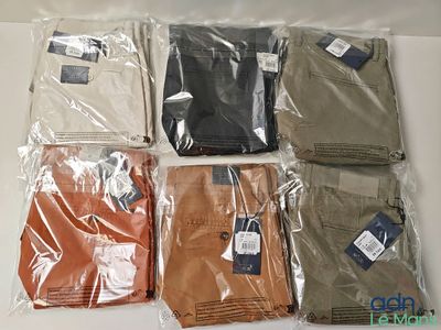 Plusieurs pantalons pour hommes sont emballés dans des sacs en plastique sur une table