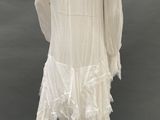the back of a mannequin wearing a white dress with fringes on it