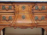 a wooden chest of drawers with a marble top