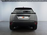 the rear end of a silver car in a white room