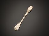 a close up of a spoon on a table with a black background
