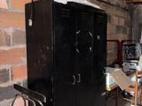 a black locker in a room with a brick wall