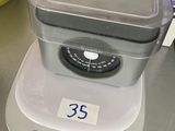 une balance posée sur un comptoir, avec un récipient dessus