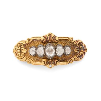 un gros plan d'une broche en or et diamants sur fond blanc