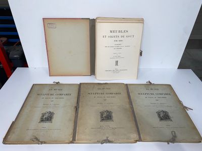trois vieux livres posés les uns à côté des autres sur une table blanche