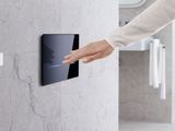 a woman that is touching a button on a wall