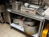 une cuisine avec beaucoup de casseroles et de poêles sur le comptoir
