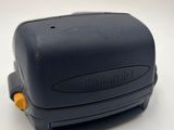 a black stapler with a yellow handle on a white surface