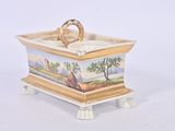 a small box with a painting on it on a white surface
