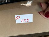 a person holding a box with a sticker on it