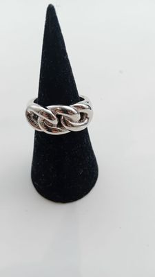un gros plan d'une bague en argent posée sur un cône noir