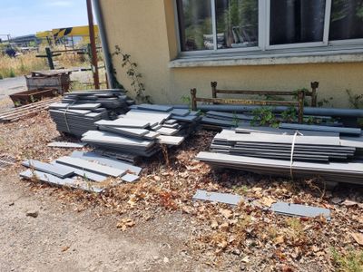 many pieces of metal sitting on the ground outside of a house