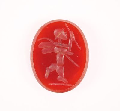 une image représentant un bouton en verre rouge sur lequel figure un homme tenant une épée