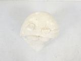 a white sculpture of a face on the wall
