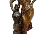 bronze statue of a woman with a vase on a pedestal