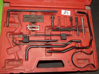 une mallette rouge contenant des outils, posée sur une table