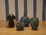 three vases sitting on a wooden table with a striped wall in the background