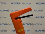 an orange plastic object with a black handle on top of a table