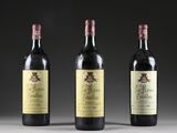 three bottles of wine are lined up on a table