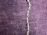 un gros plan d'un collier posé sur un fond violet