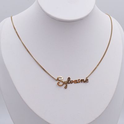 un gros plan d'un collier en or sur lequel est gravé le mot « supreme »